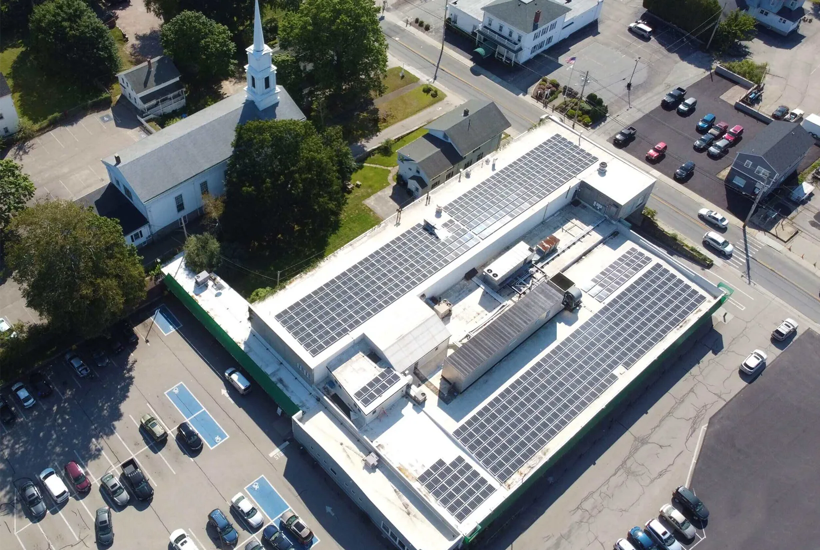 Commercial building with rooftop solar panels, aerial view